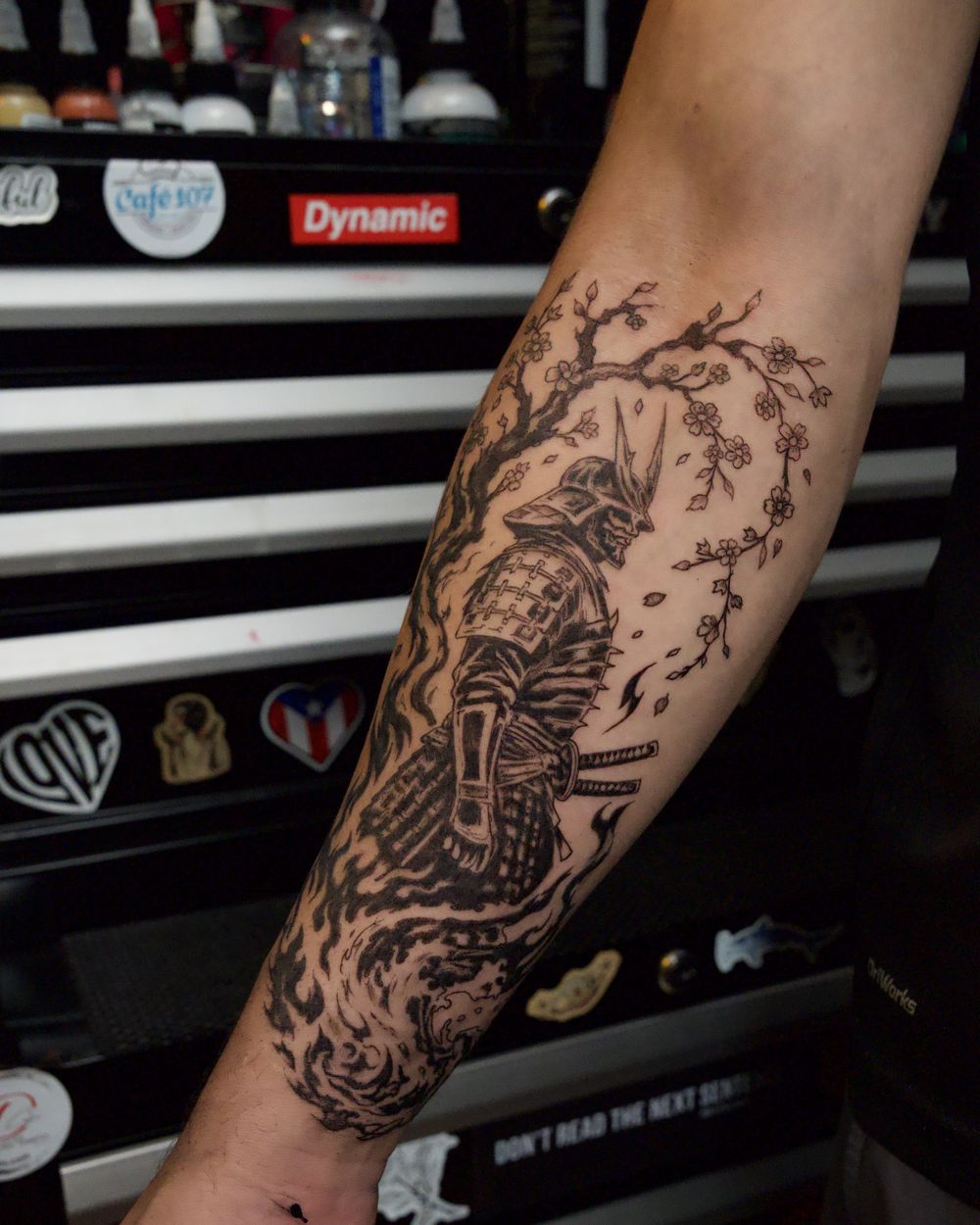 Blackwork samurai warrior with cherry blossoms covering the forearm, by Rodney Alacan
